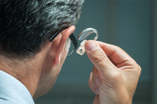 Hearing aid by man's ear-1
